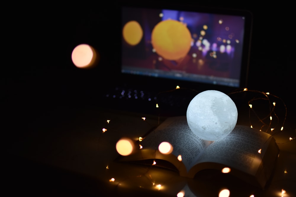 a white ball sitting on top of an open book