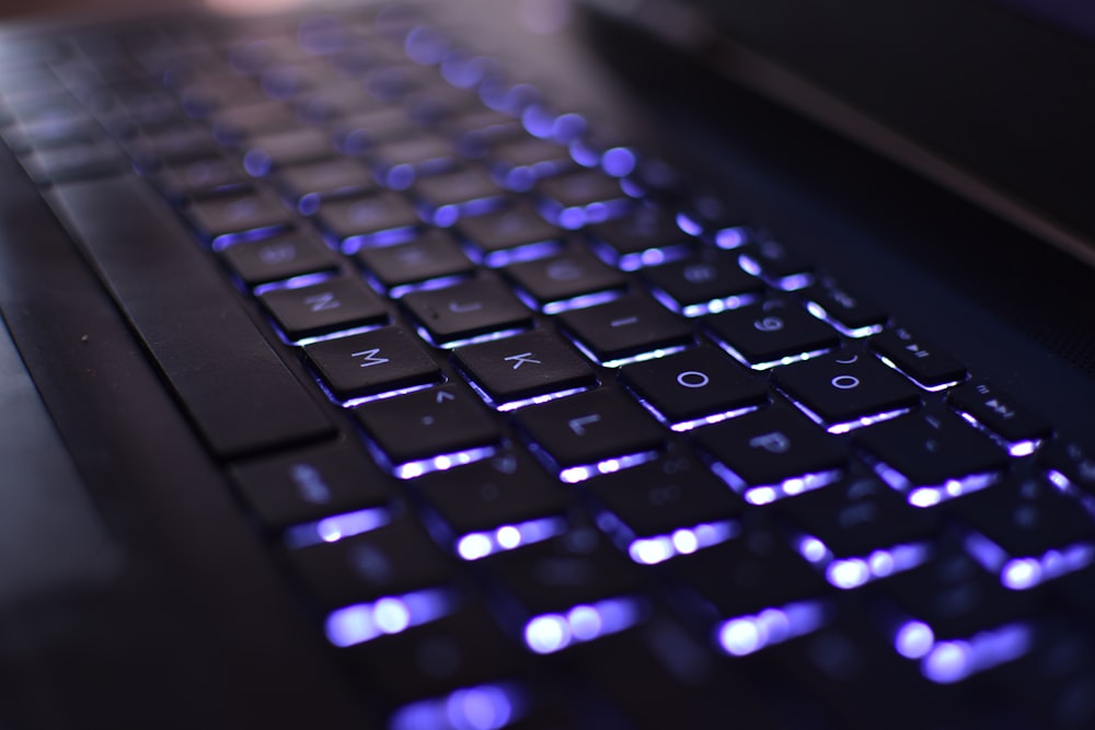 a close up of a computer keyboard with blue lights