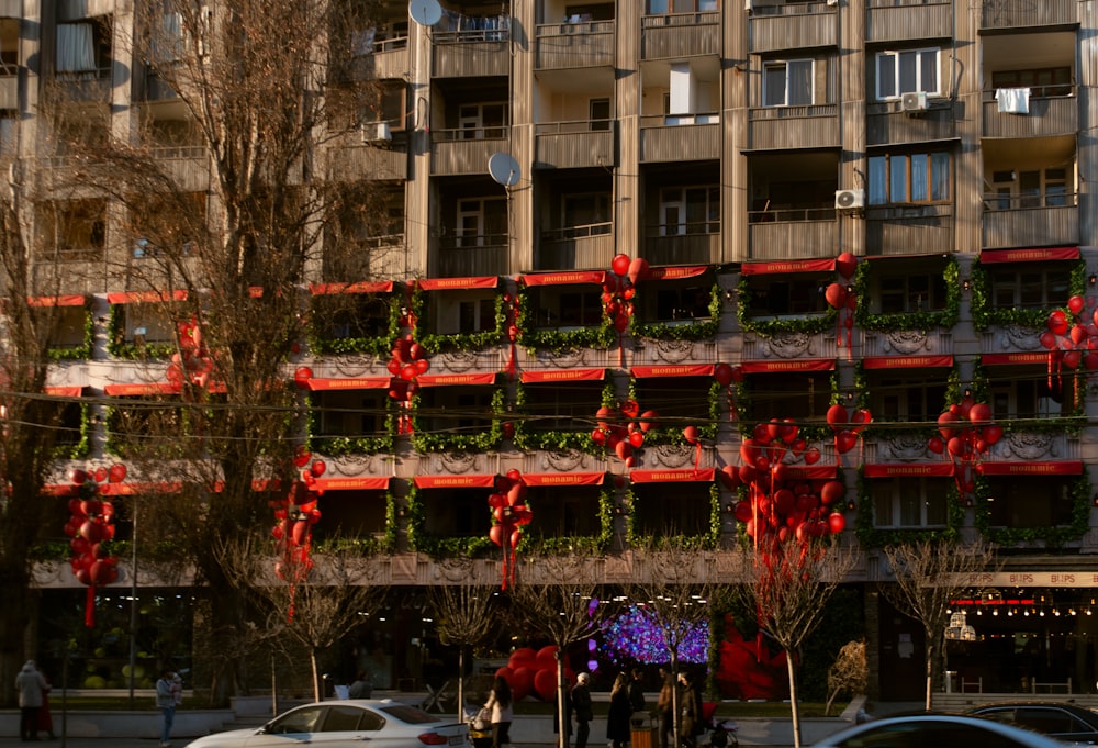 a tall building with a bunch of red ribbons hanging from it's sides