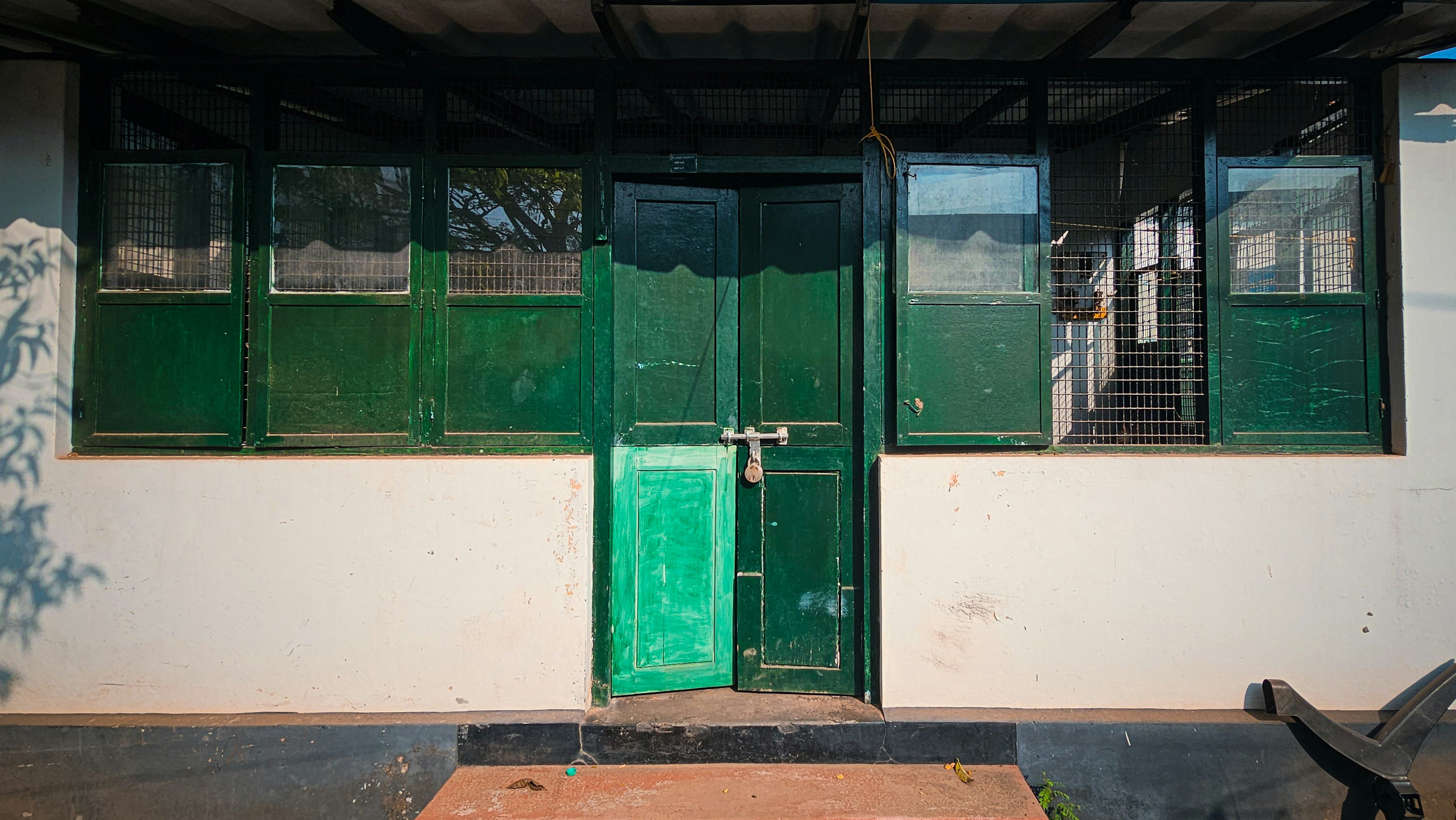Une porte verte se trouve devant un bâtiment blanc