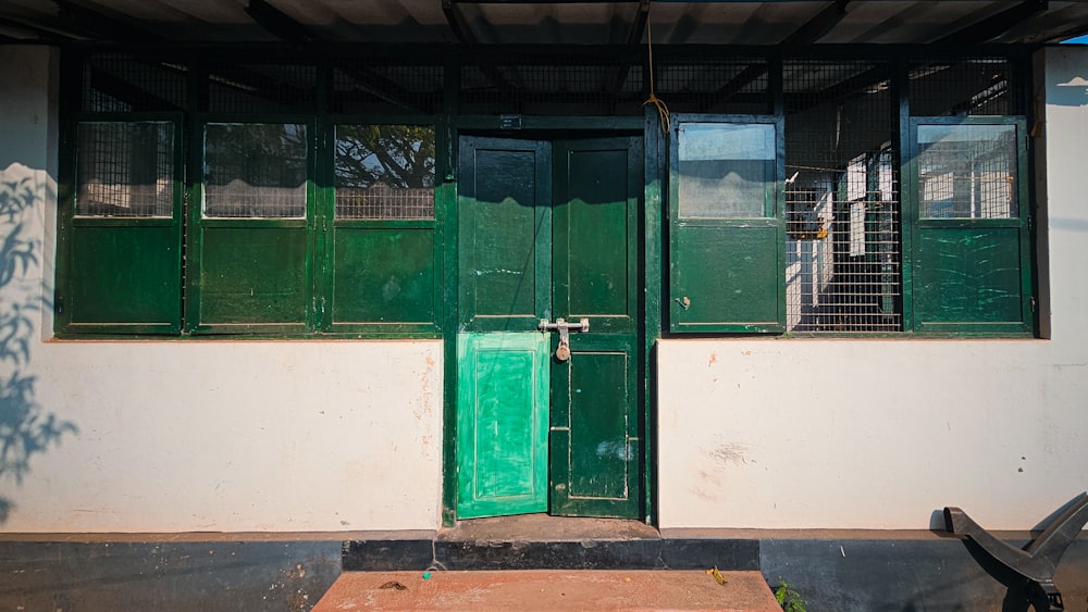 a green door sits in front of a white building