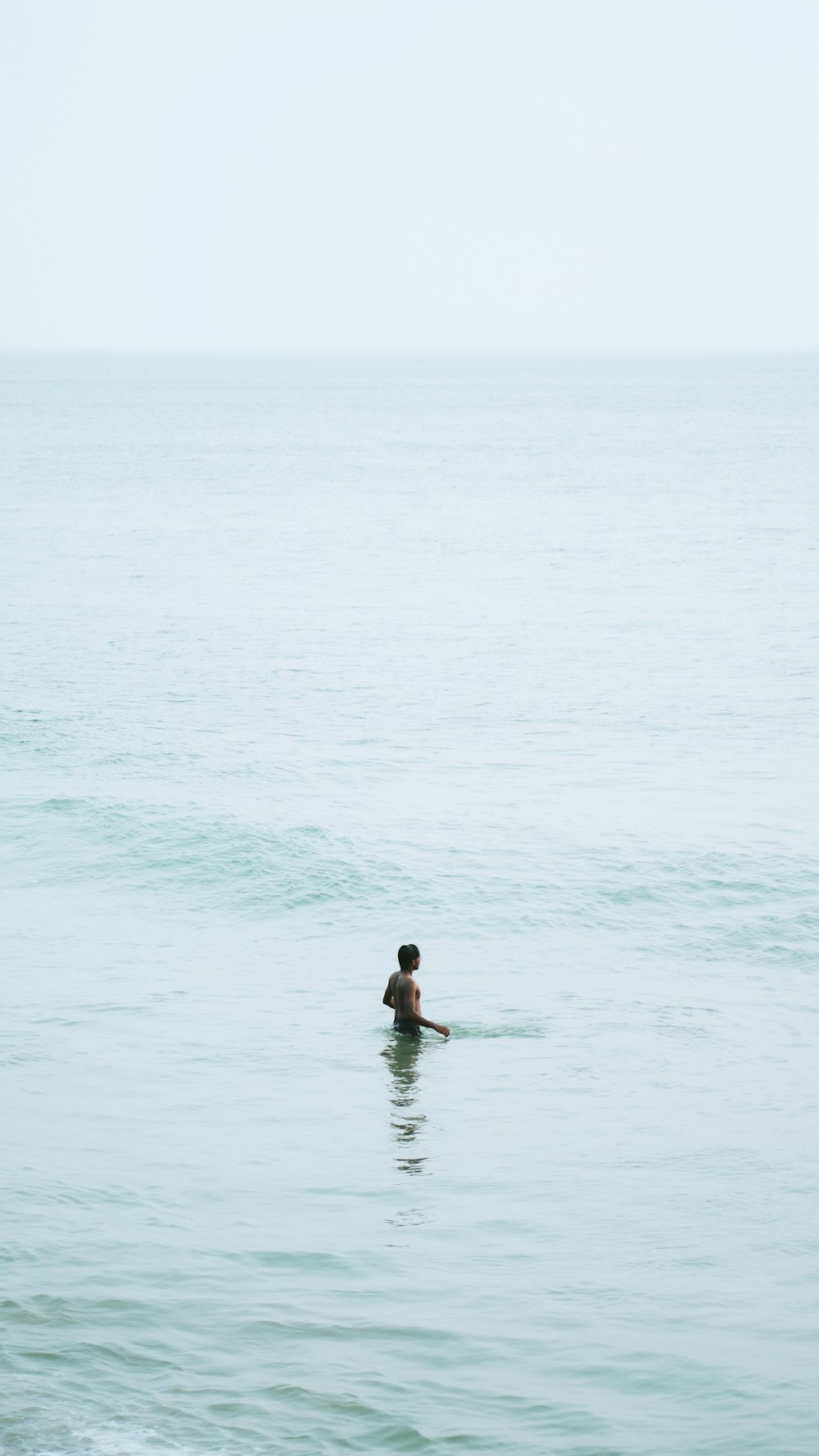 a person swimming in the ocean on a clear day