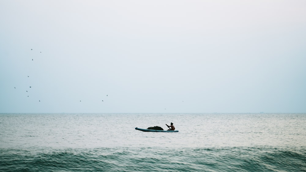 a person in a small boat in the middle of the ocean