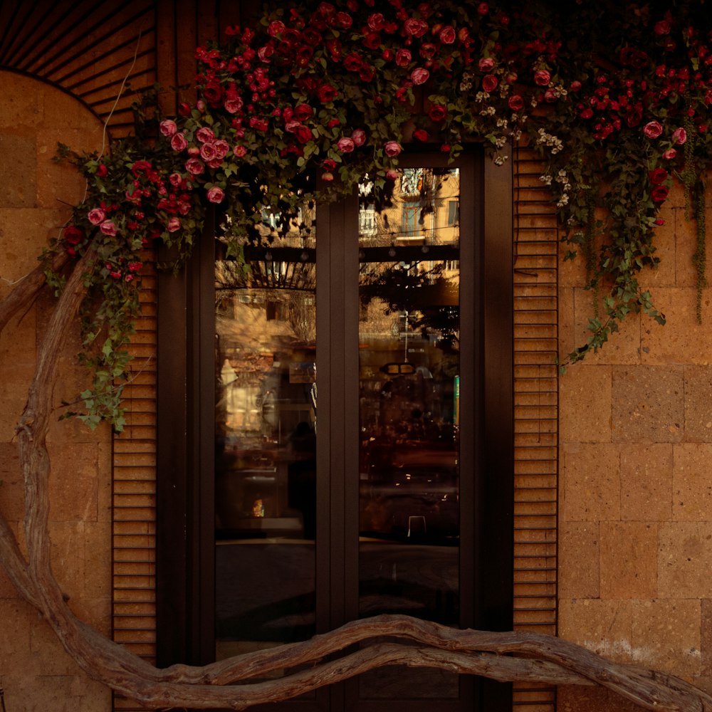 a wooden bench sitting in front of a window covered in flowers