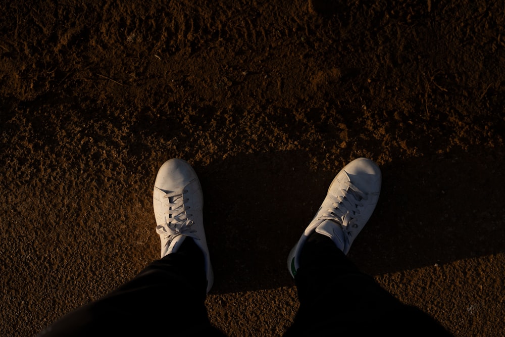 uma pessoa em pé no chão com os sapatos