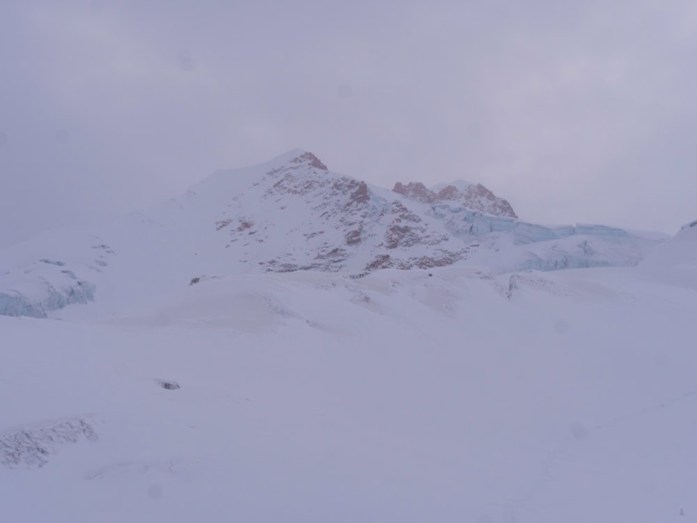 une personne sur des skis dans la neige avec une montagne en arrière-plan