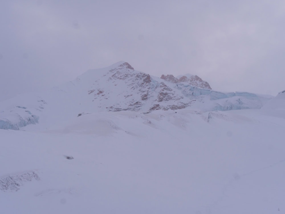 a person on skis in the snow with a mountain in the background