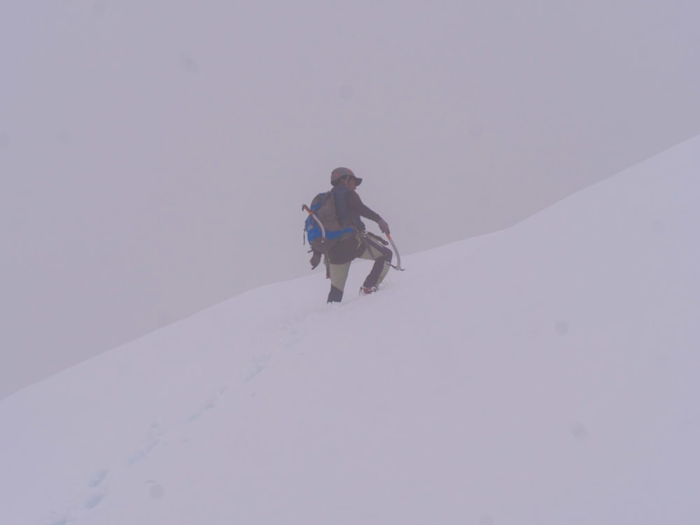 a man walking up a snow covered hill