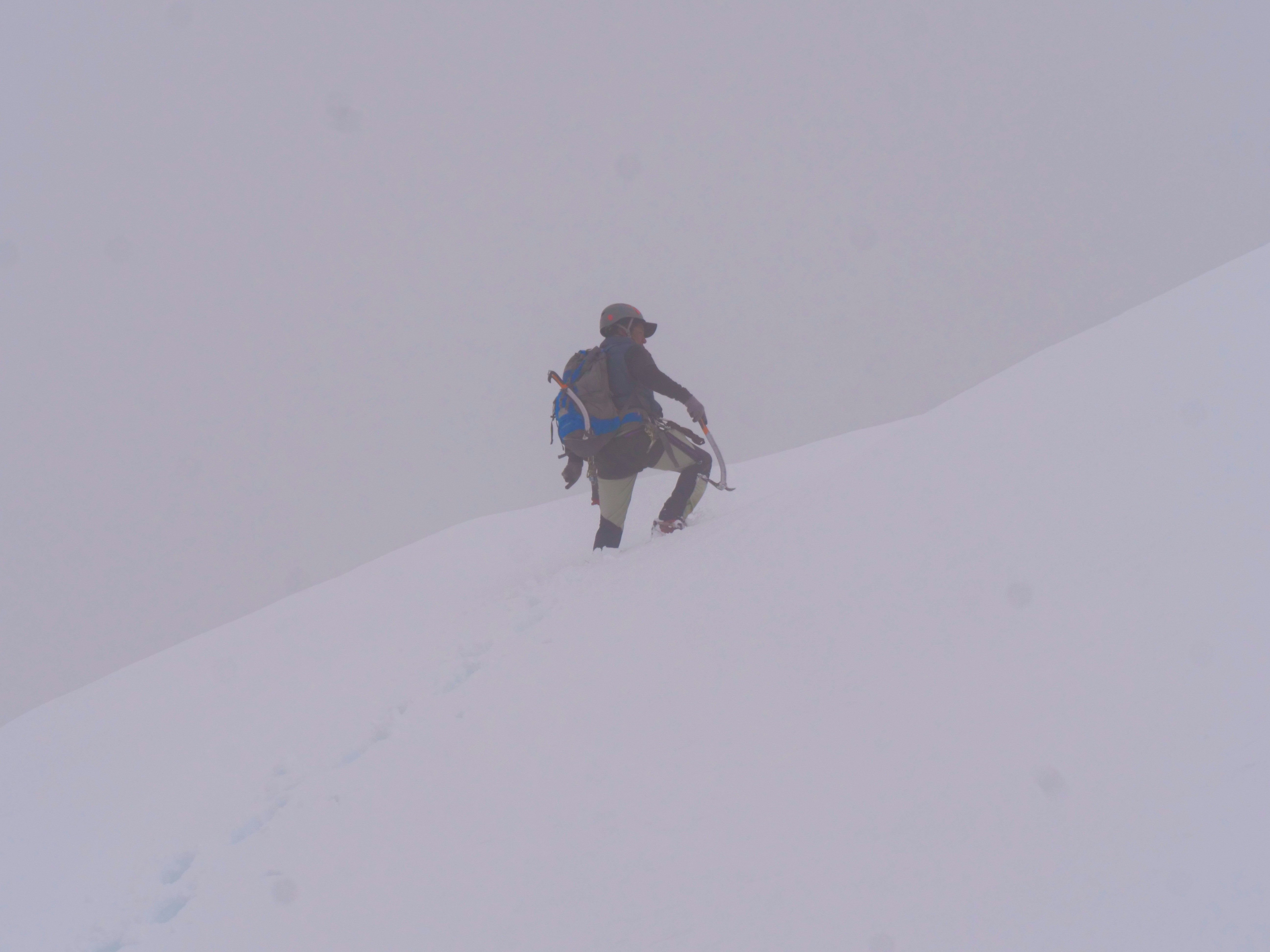 a man walking up a snow covered hill