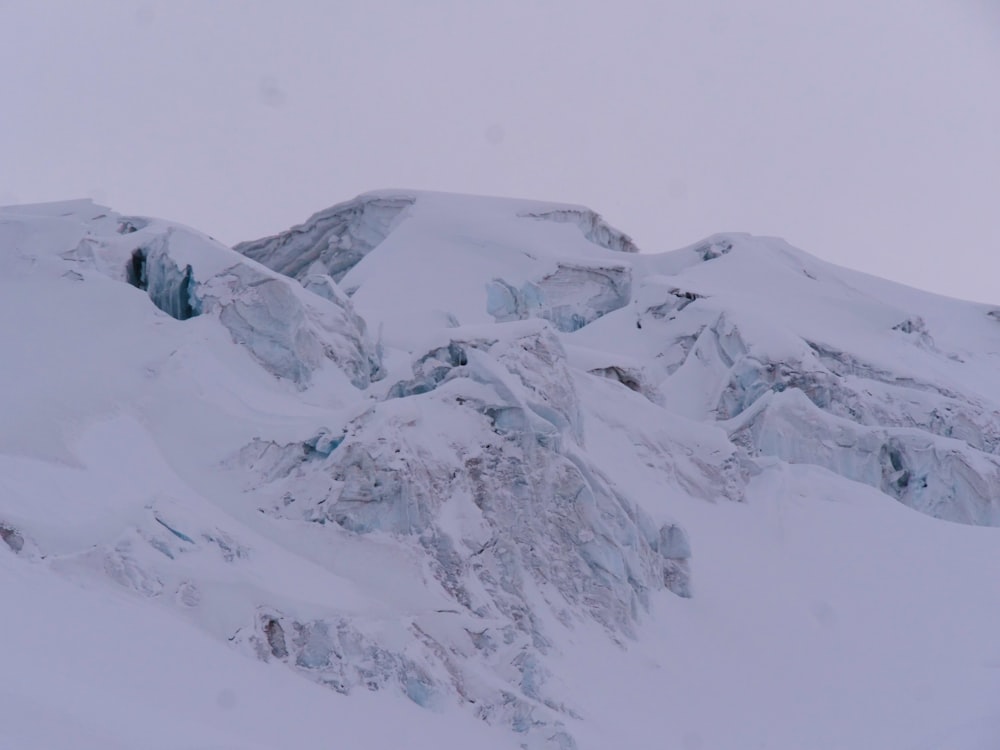 a mountain covered in snow with a sky background