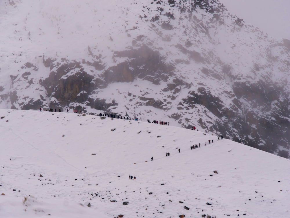 a group of people walking up a snow covered hill