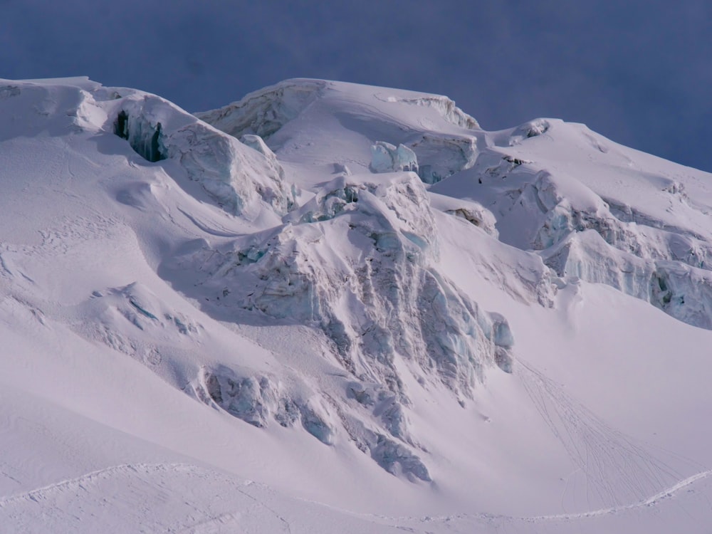 a large mountain covered in snow under a blue sky