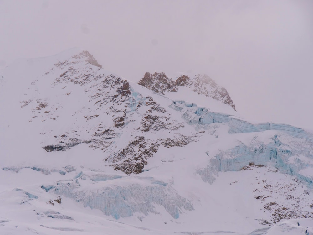 a mountain covered in snow with a sky background