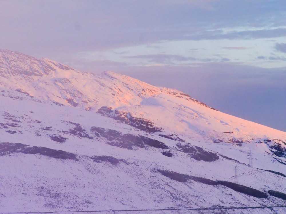 a snowboarder is going down a snowy mountain