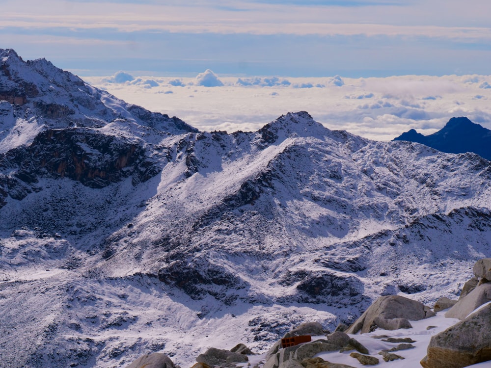 a mountain range covered in snow under a blue sky