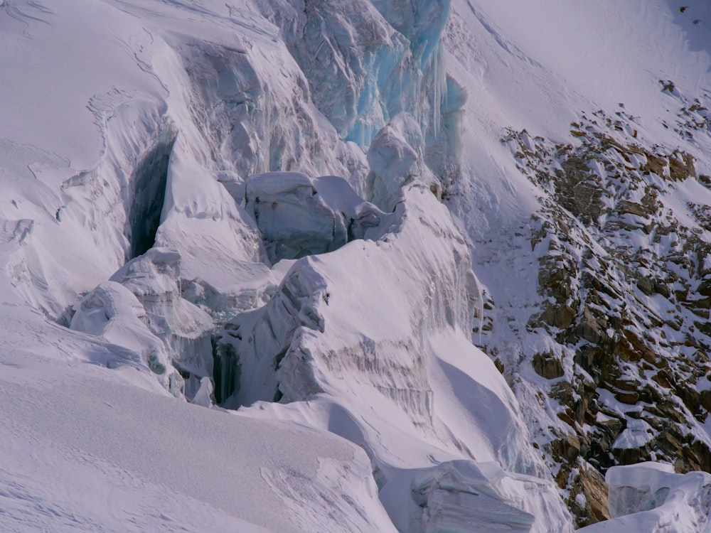 a man riding skis down the side of a snow covered mountain