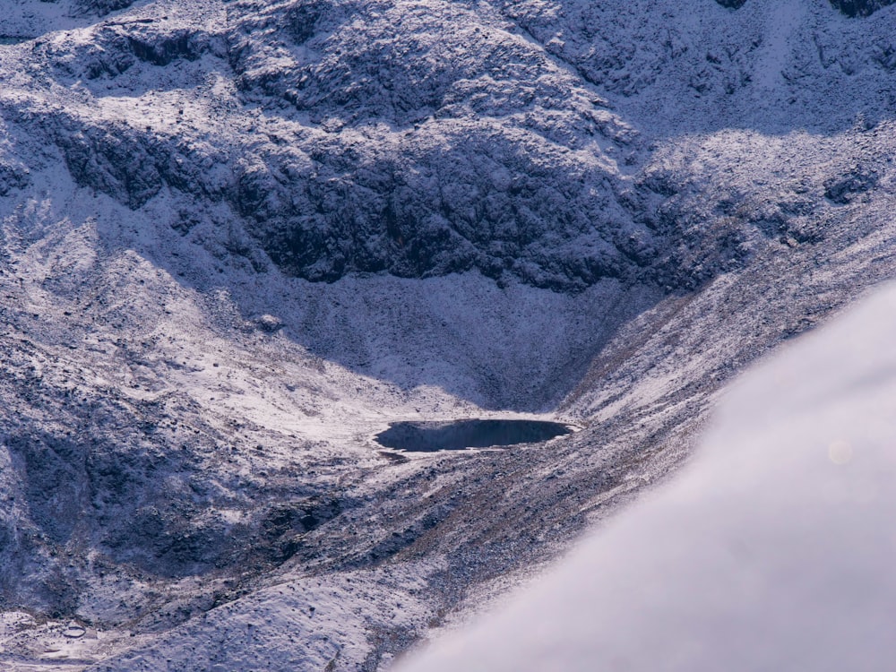 a snow covered mountain with a lake in the middle