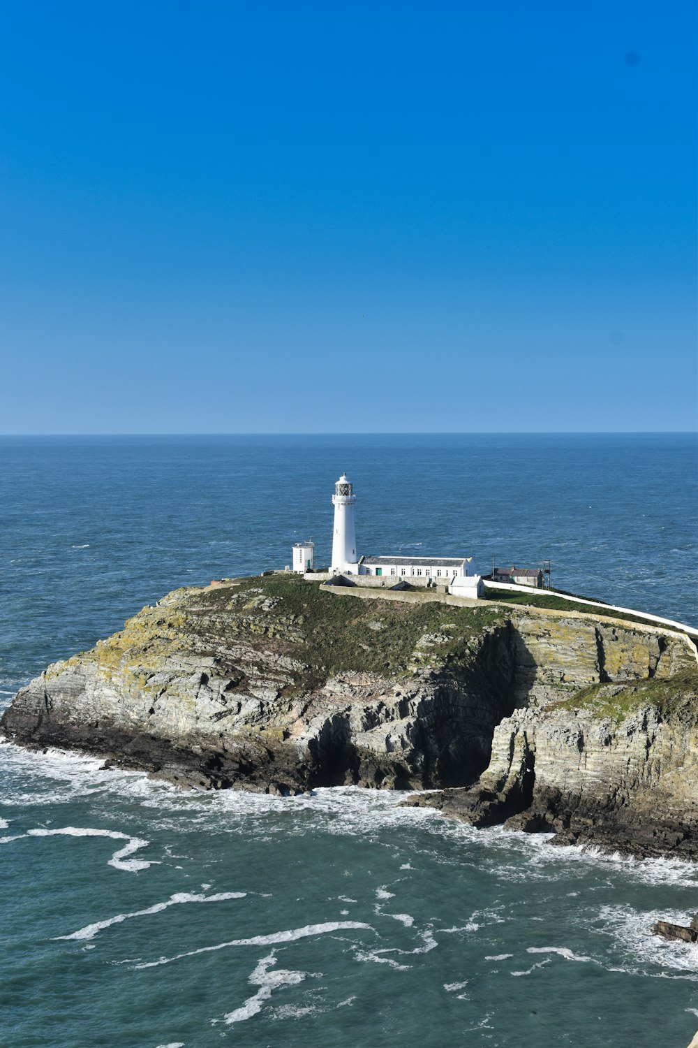 a lighthouse on top of a cliff near the ocean