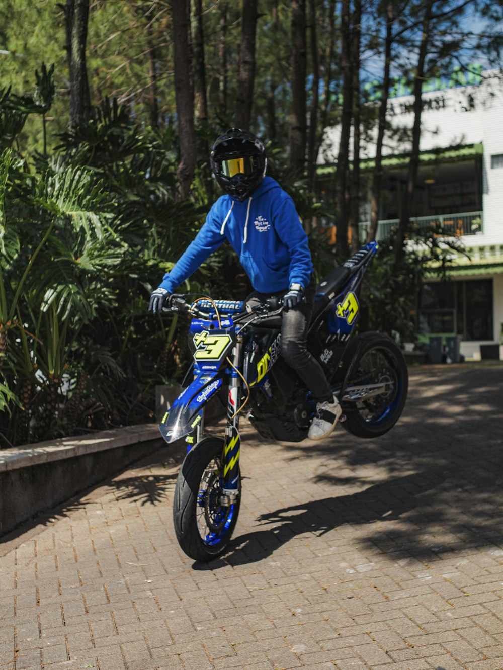 a man riding a dirt bike on top of a brick road