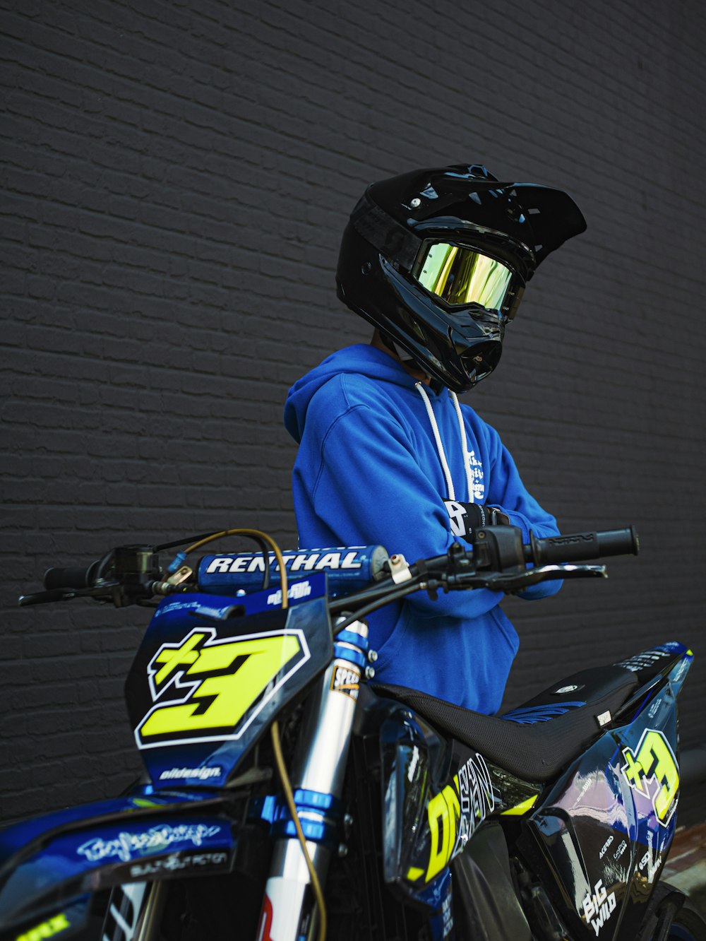 a person in a blue jacket and helmet on a dirt bike