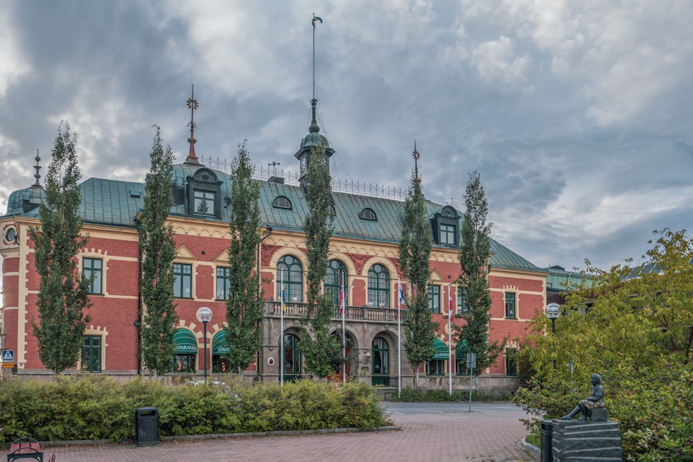 a large red brick building with a green roof