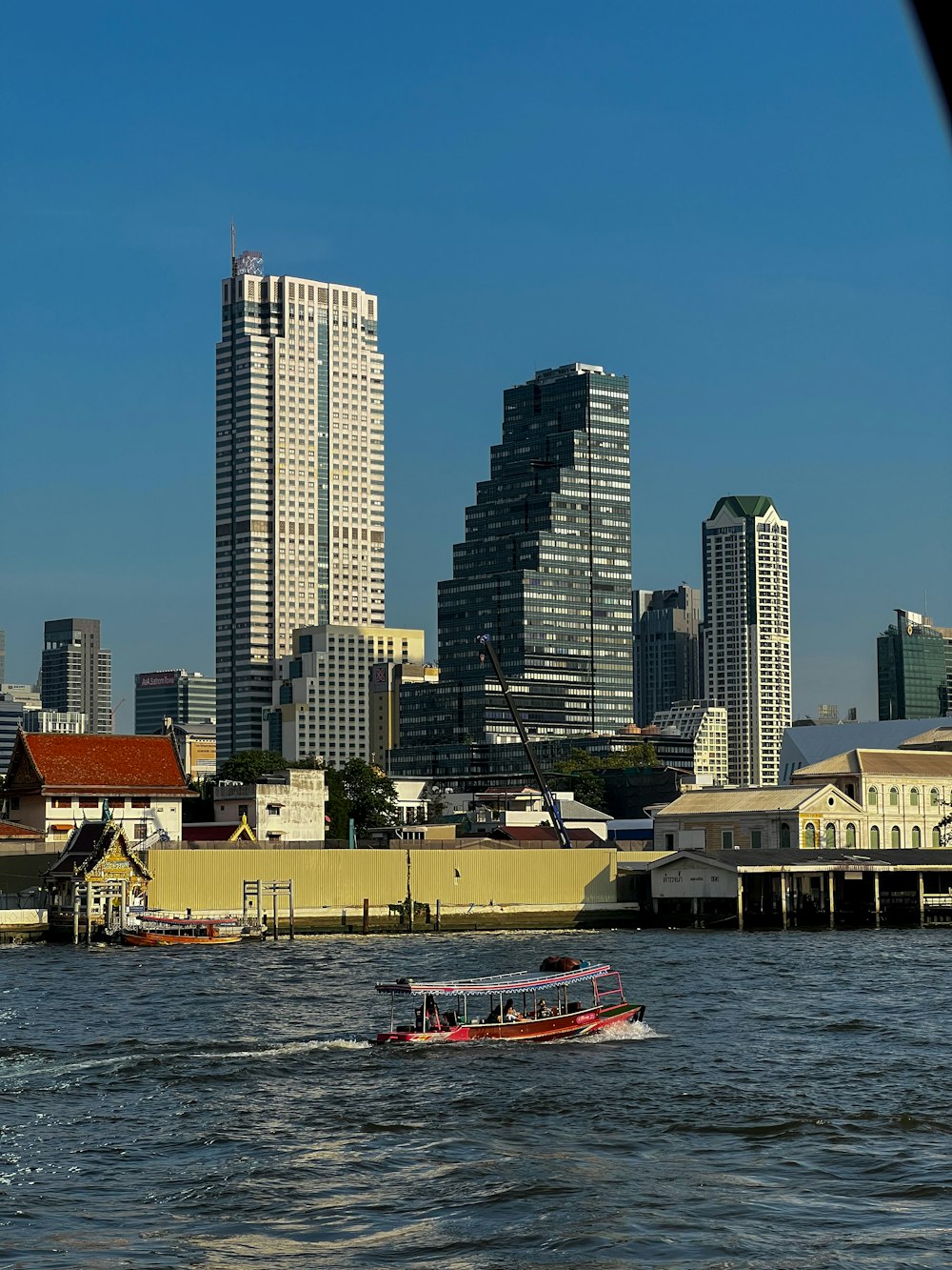 a boat traveling down a river next to tall buildings