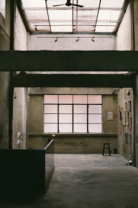 an empty room with a ceiling fan and windows