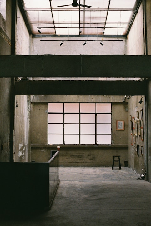 an empty room with a ceiling fan and windows