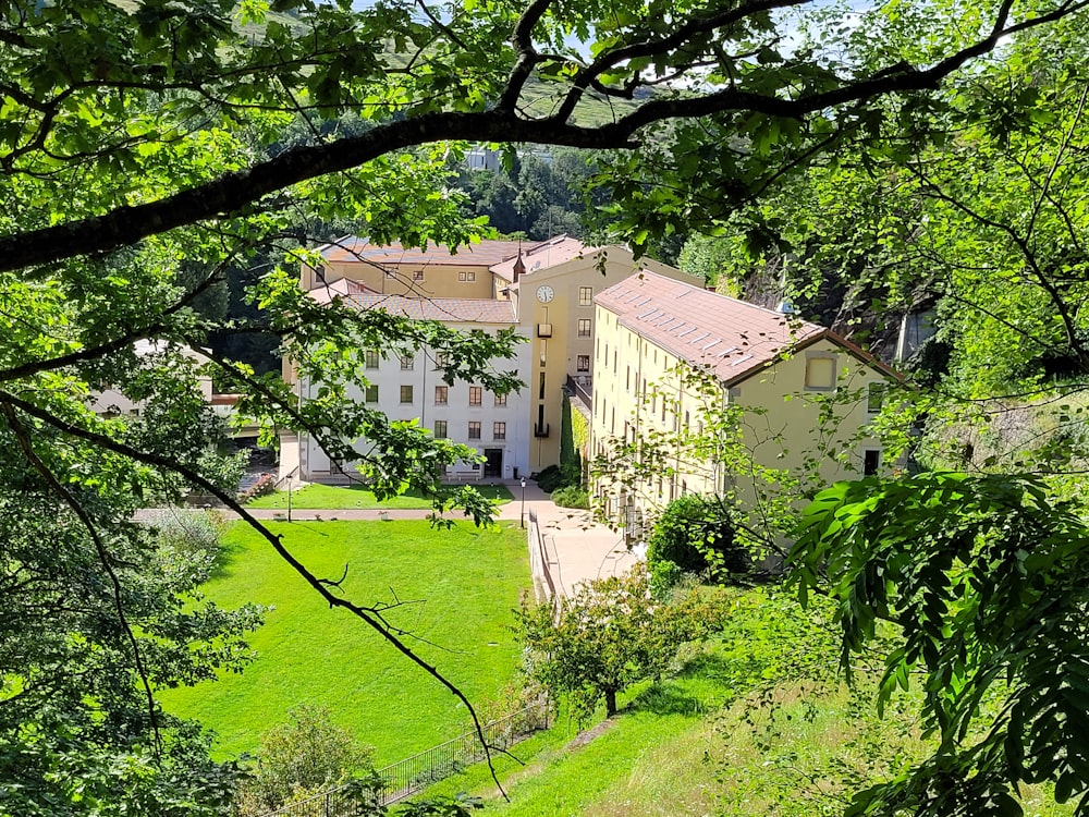 a large white building surrounded by lush green trees