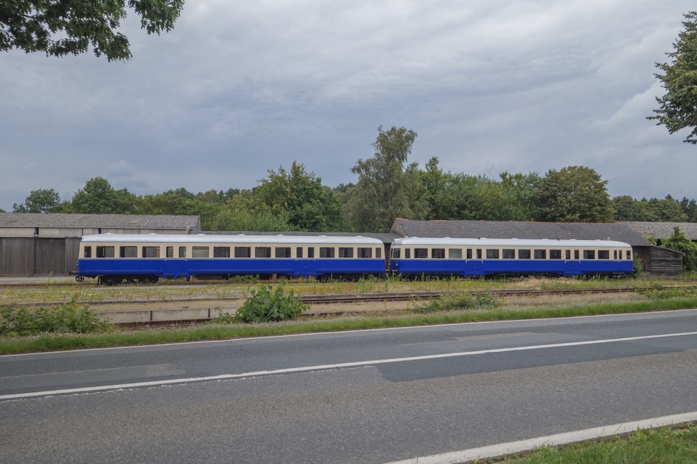 a blue and white train traveling down train tracks