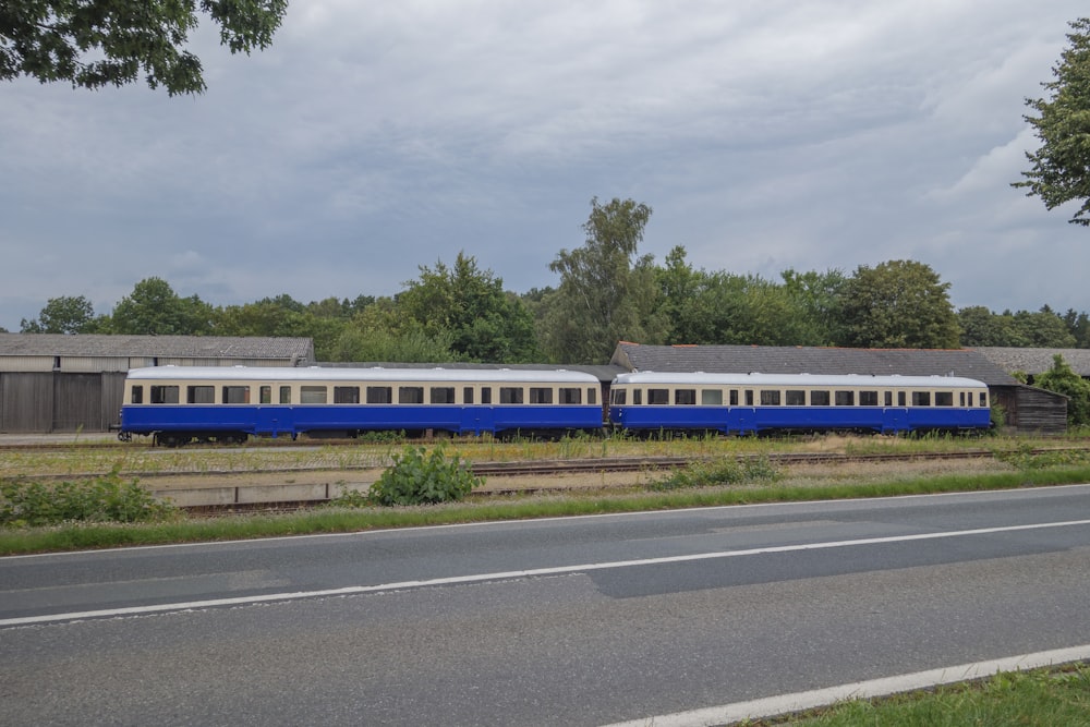 um trem azul e branco viajando pelos trilhos do trem