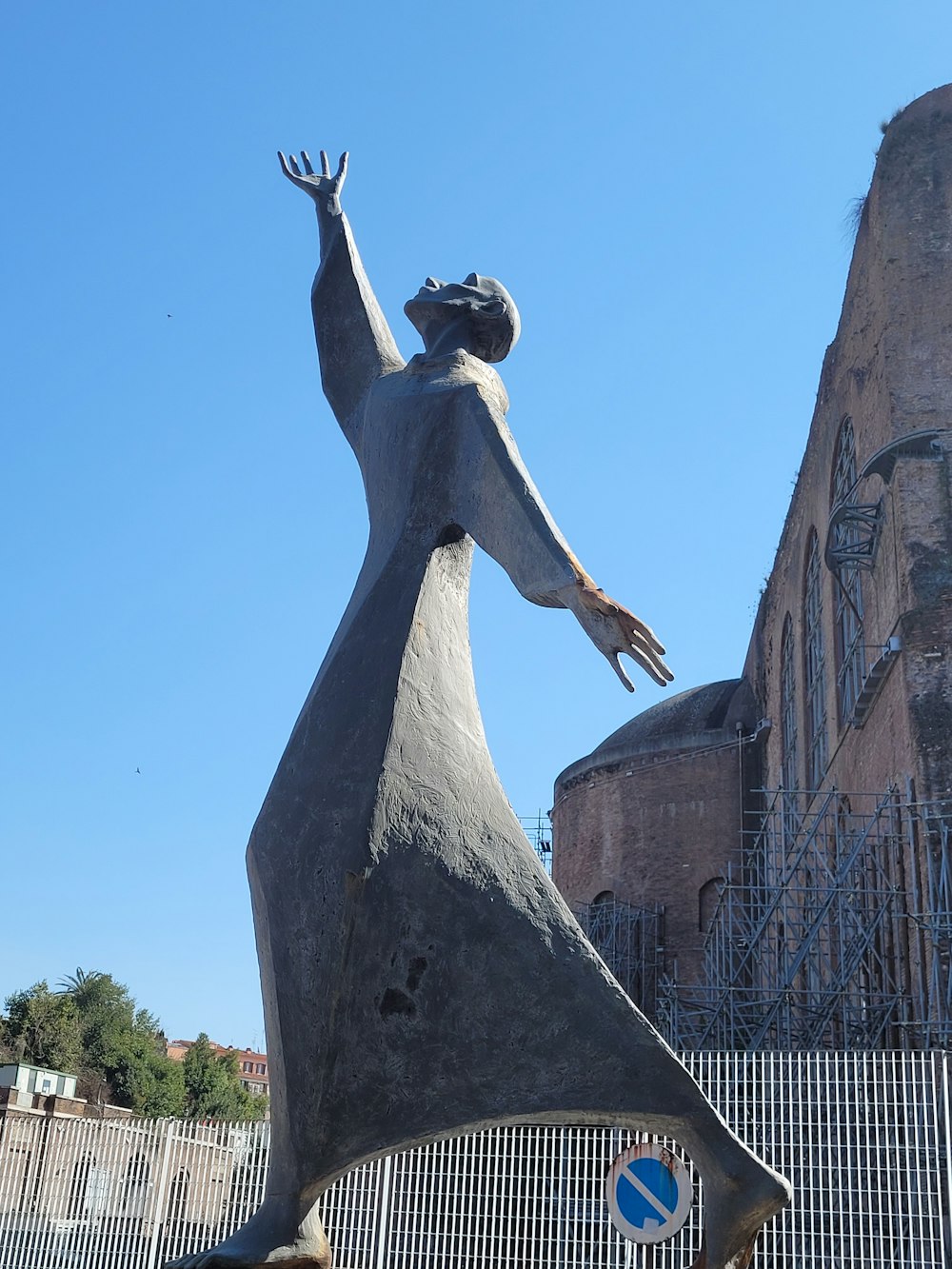 a statue of a woman reaching up to the sky