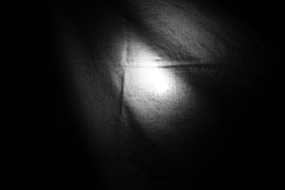 a black and white photo of a light in the dark