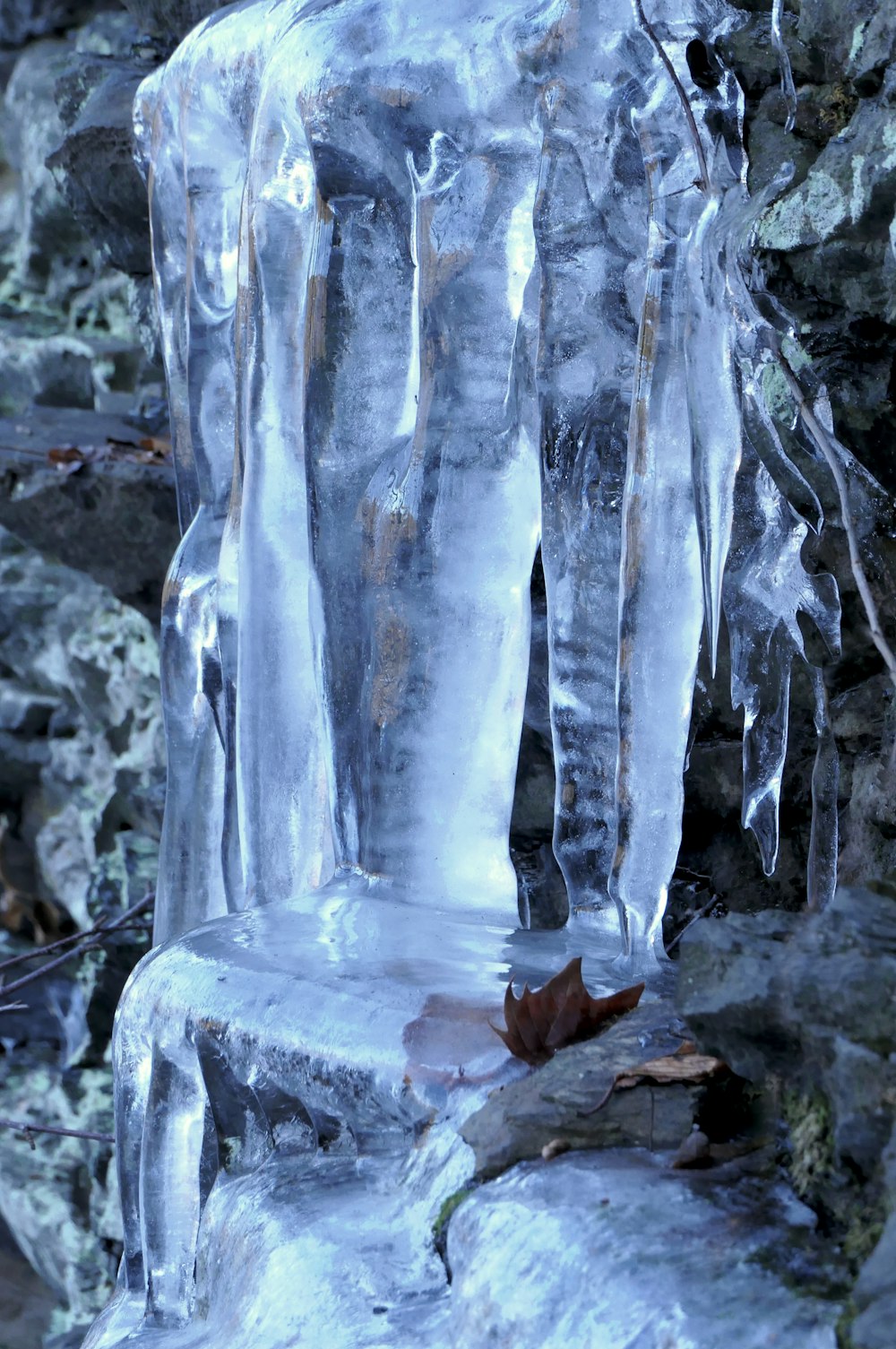 a frozen waterfall with a leaf on it