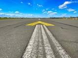 a yellow arrow painted on a runway