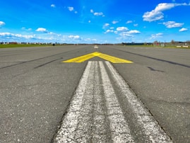 a yellow arrow painted on an empty runway