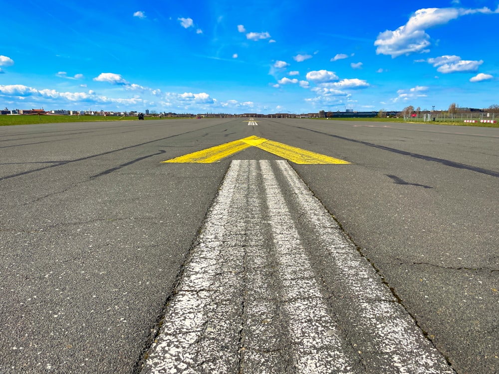 a yellow arrow painted on an empty runway