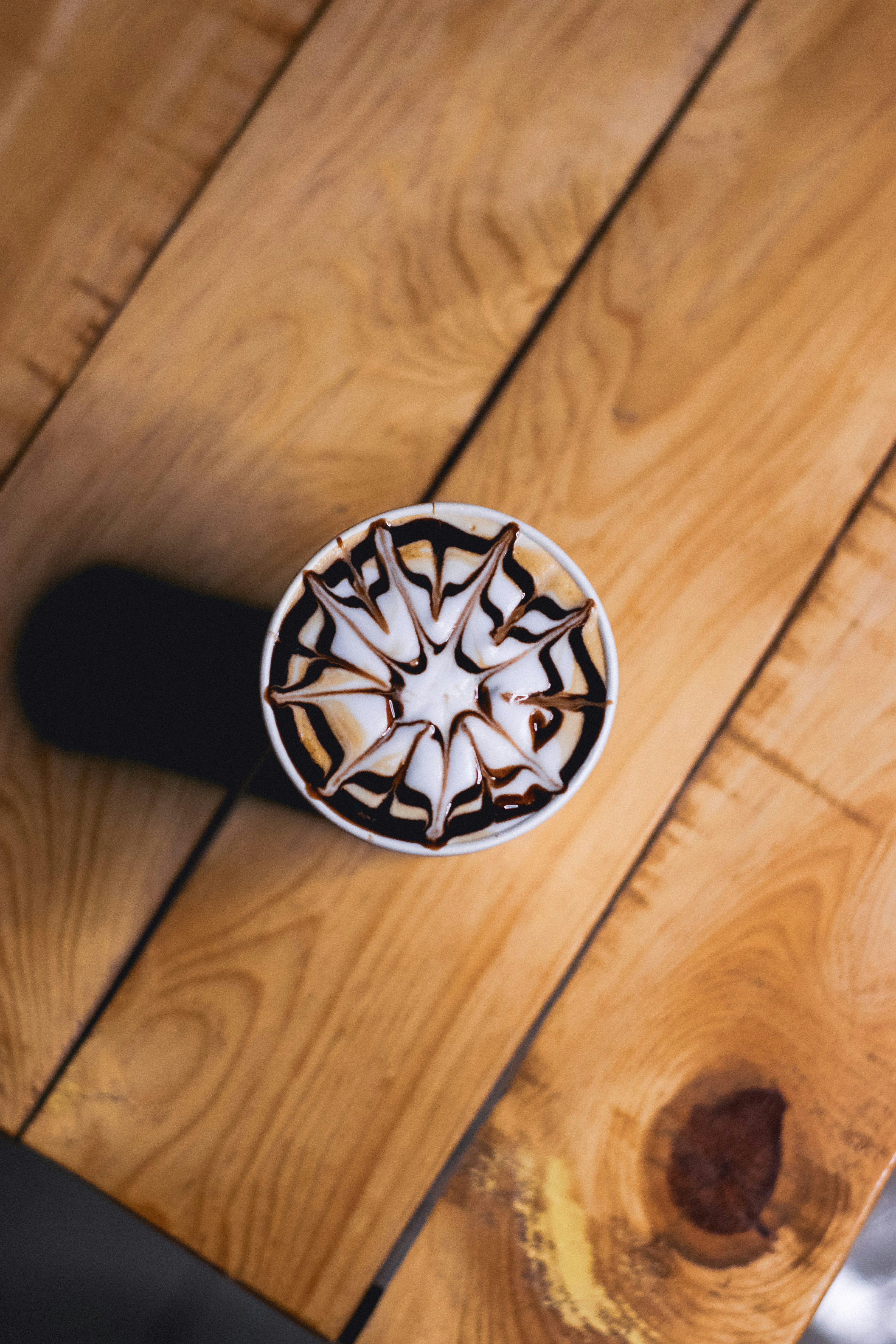a wooden table topped with a white and black plate