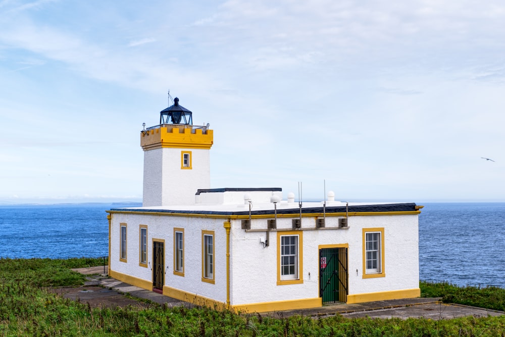 a white and yellow building with a light house on top of it