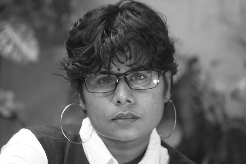a black and white photo of a woman wearing glasses