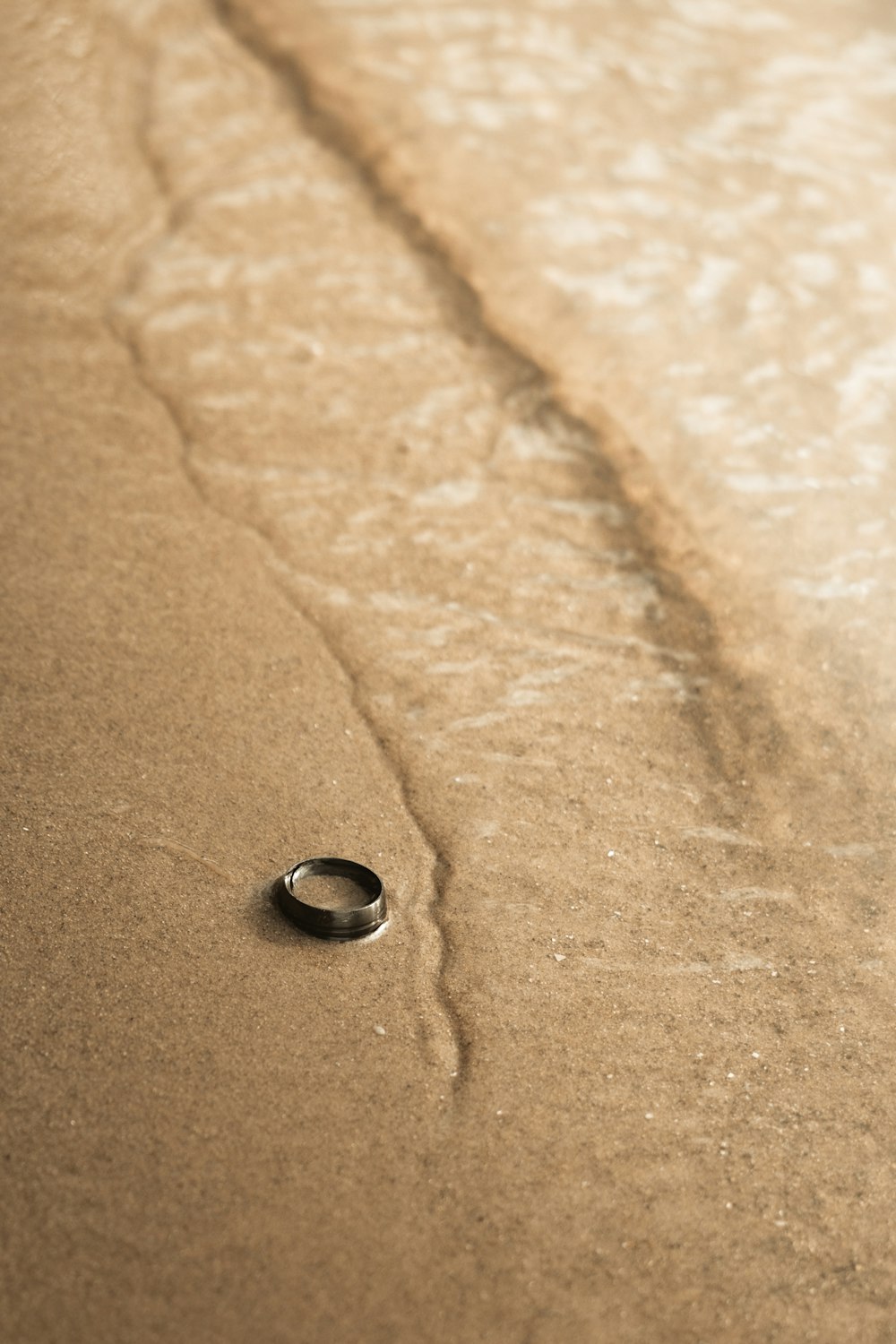 a ring sitting in the sand on the beach