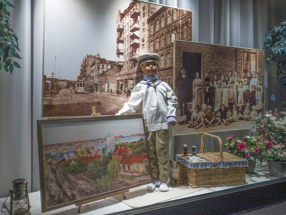 a display case with a teddy bear and a painting