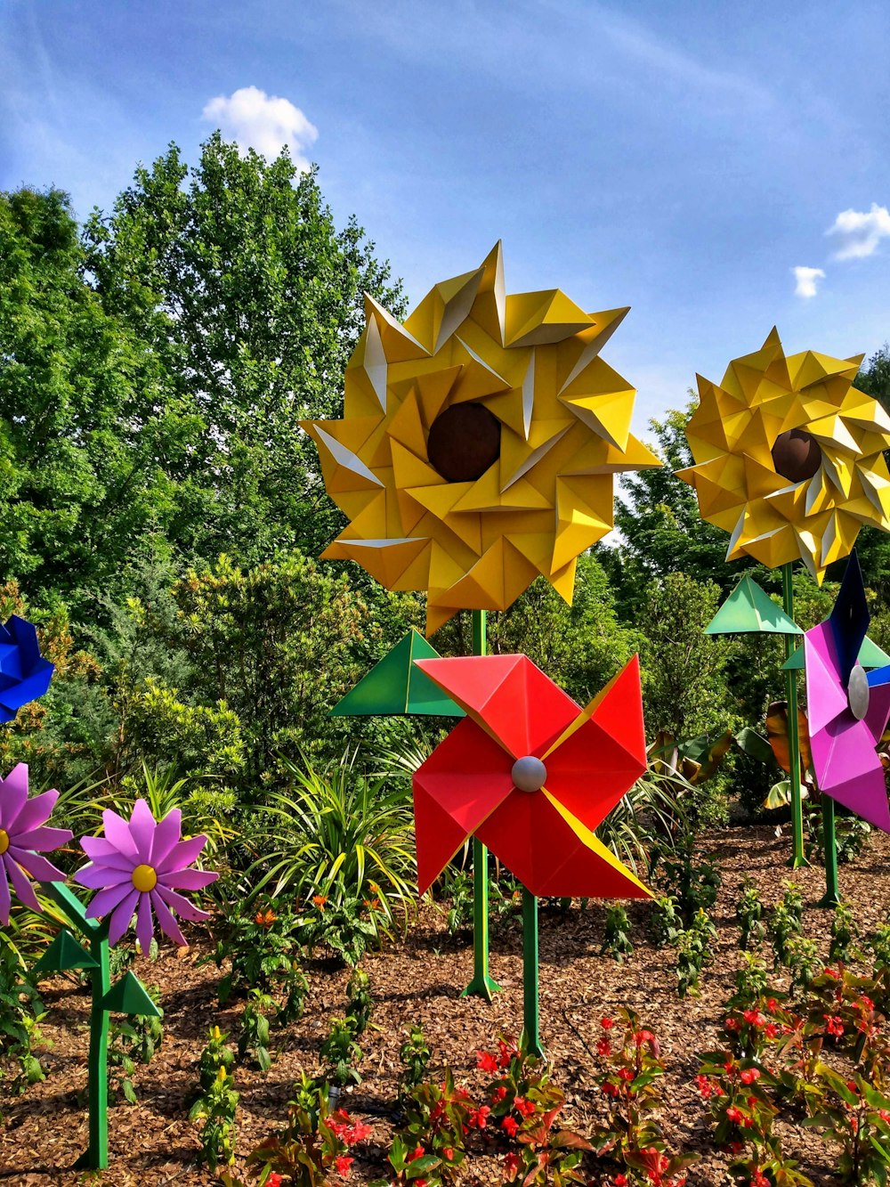 a group of colorful paper flowers in a garden