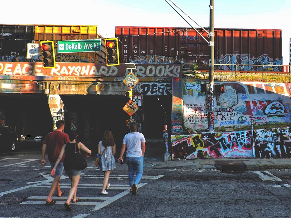 a group of people walking across a street