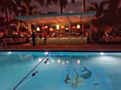 a large swimming pool with a bar in the background