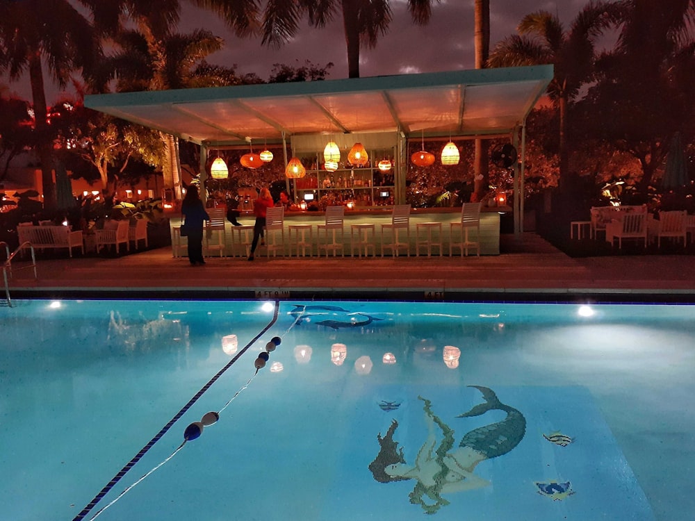 a large swimming pool with a bar in the background