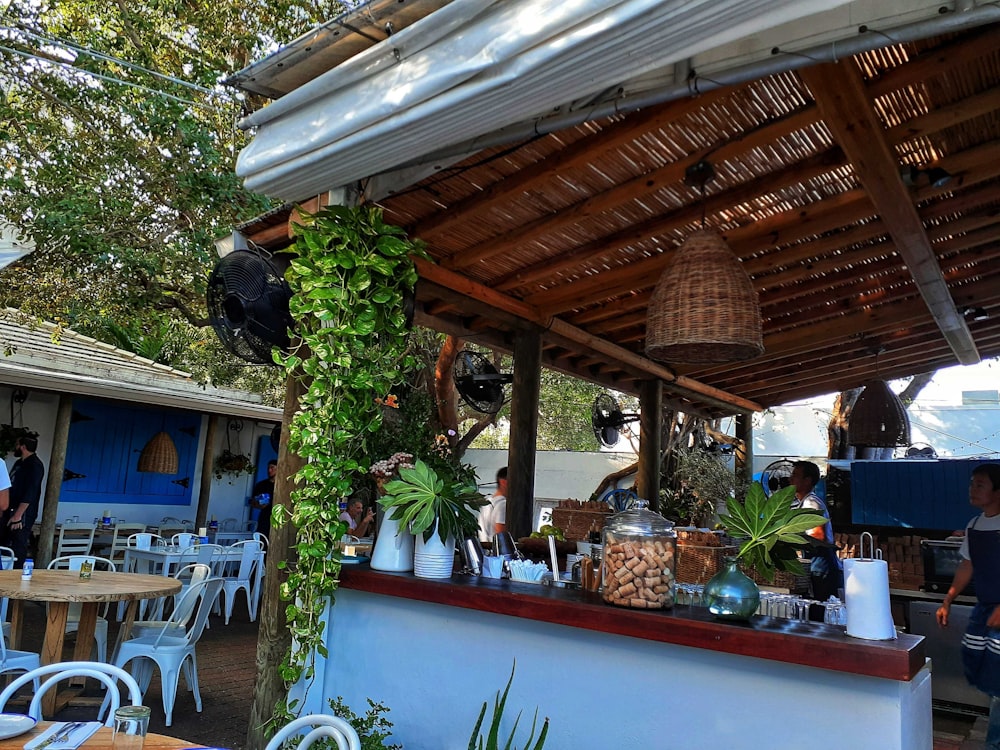 a restaurant with tables and chairs covered in plants