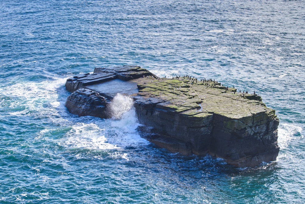 a rock outcropping in the middle of the ocean