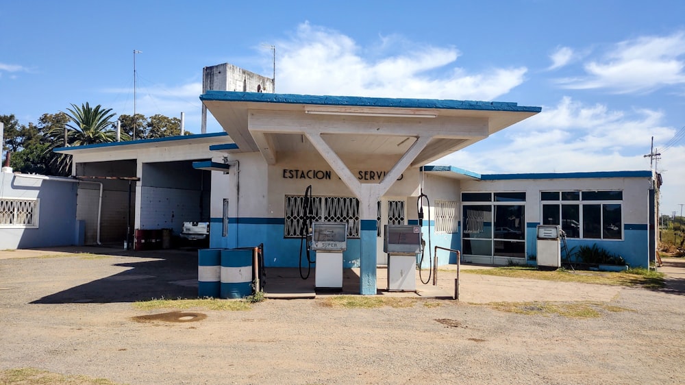 an old gas station with a blue and white roof