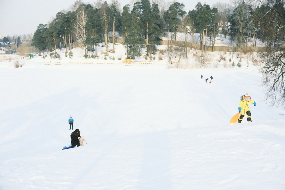 a group of people riding snowboards down a snow covered slope